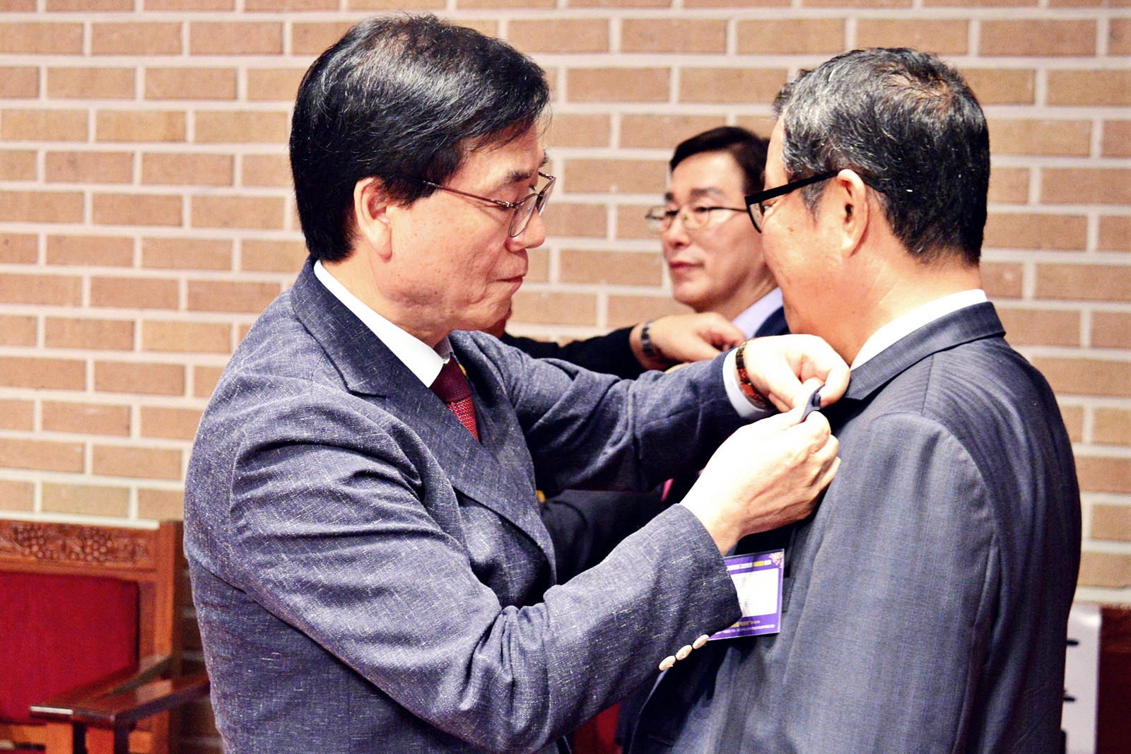 ▲ 김상석 직전 총회장(왼쪽)이 김성복 총회자에게 배지를 달아주고 있다.